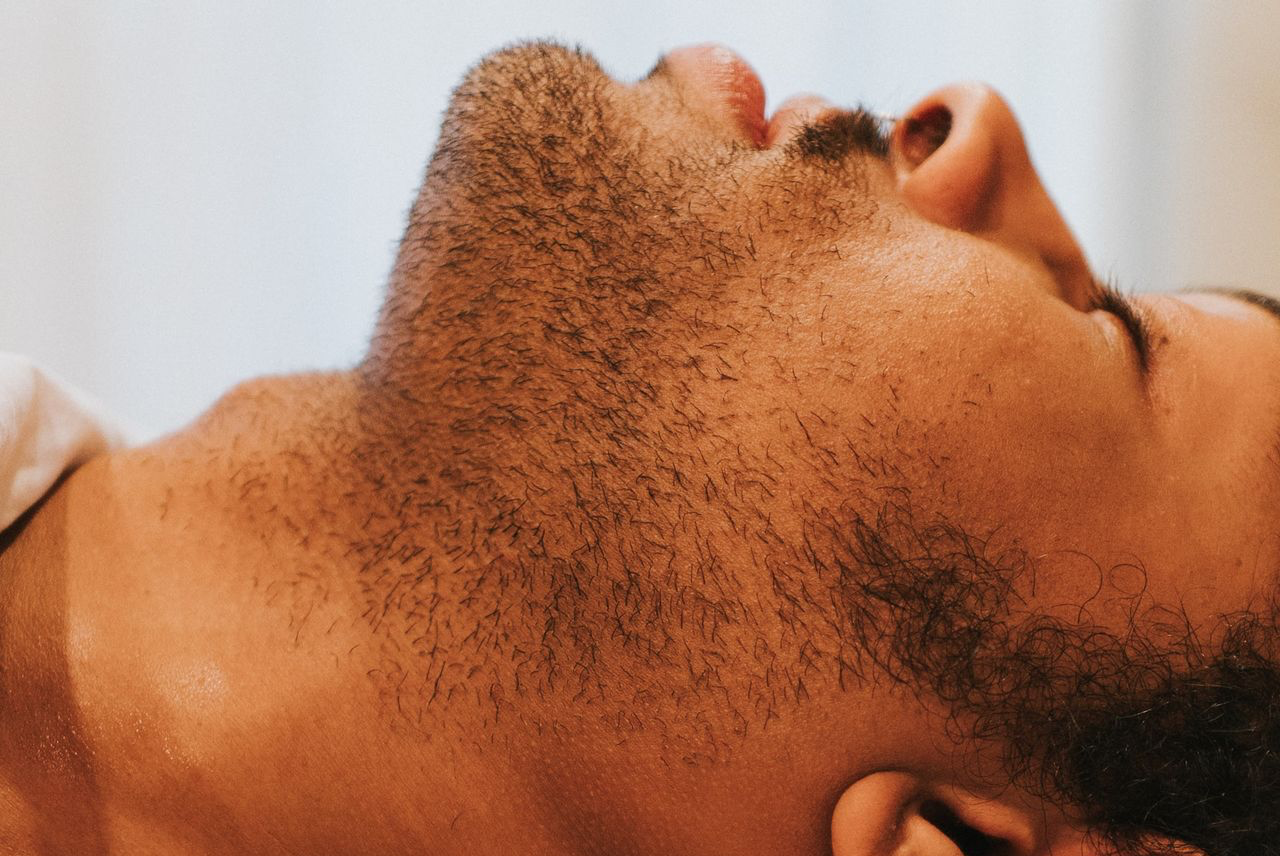 a man laying on top of a bed next to a window